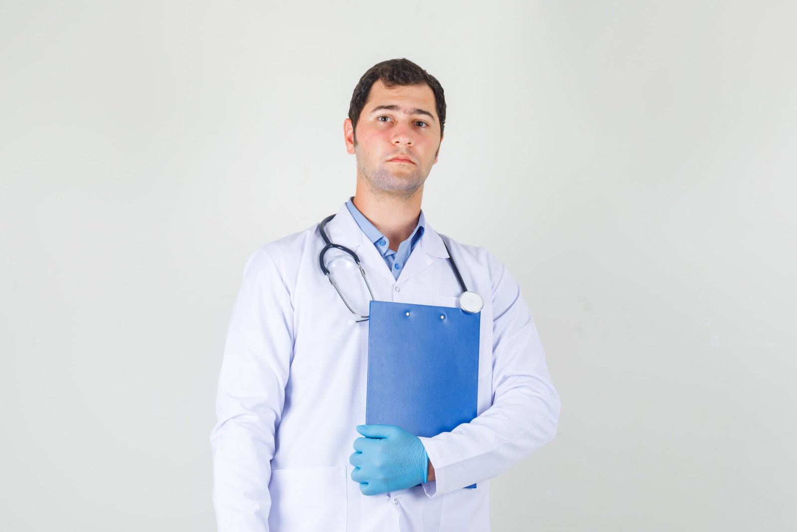 male-doctor-holding-clipboard-white-coat-gloves-looking-serious-front-view (1)